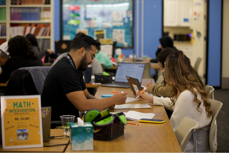 A teacher offering a student one-on-one support. 