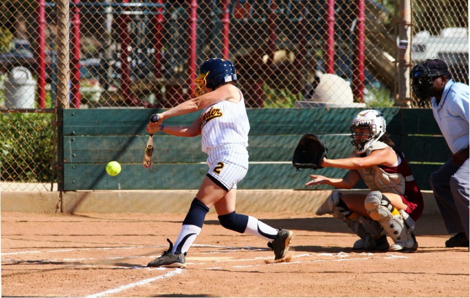 A girl playing softball outdoors.
