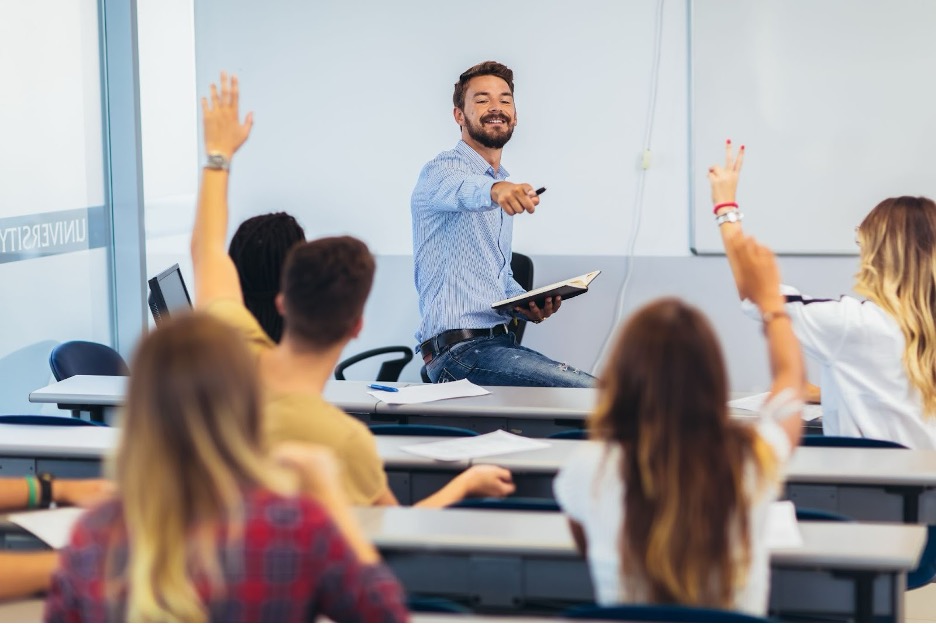 A classroom of students raising their hands.
